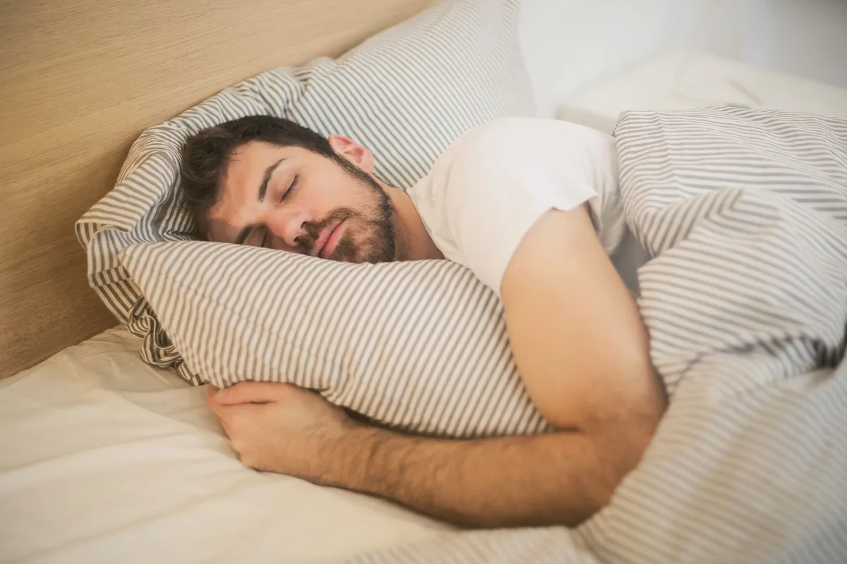 A man asleep in bed, before the first cortisol sample on waking