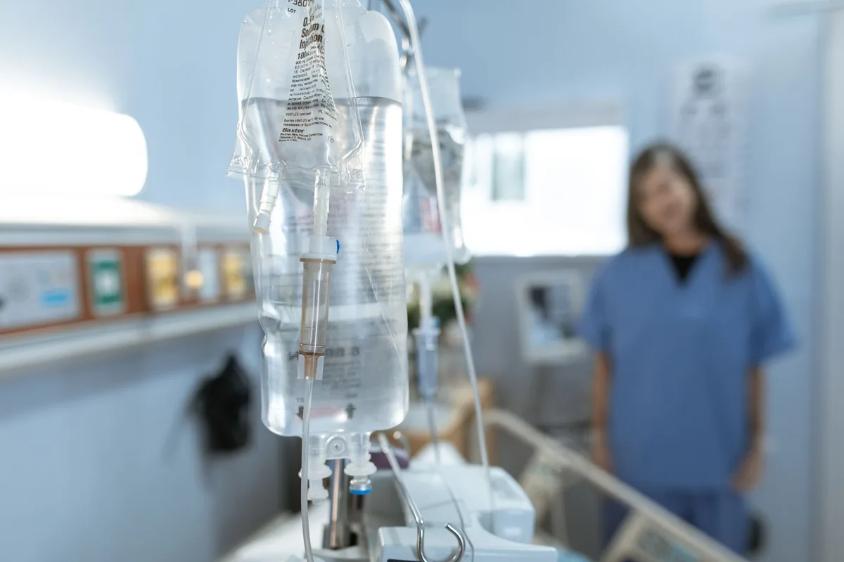 A clear IV drip bag hanging in a treatment room